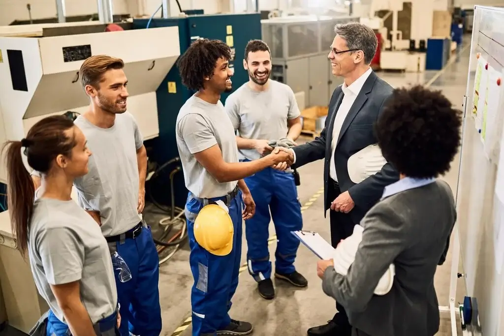happy-corporate-manager-shaking-hands-with-black-worker-after-staff-meeting-factory